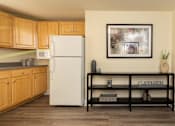 Thumbnail 7 of 26 - A kitchen with a white fridge and wooden cabinets.