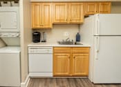 Thumbnail 6 of 27 - A kitchen with wooden cabinets and white appliances.at Deer Park Apartments, Randallstown, MD 21133