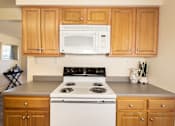 Thumbnail 7 of 36 - Wooden kitchen cabinets with white microwave and oven with gas range