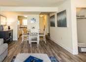 Thumbnail 5 of 32 - Living room with a table and chairs and a kitchen in the background at Seven Oaks Townhomes, Edgewood, Maryland