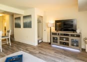Thumbnail 4 of 32 - Living room with a tv and a table with chairs at Seven Oaks Townhomes, Edgewood