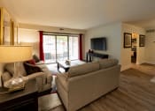 Thumbnail 7 of 28 - a living room with a couch and a chair and a television