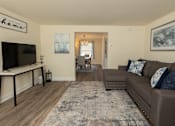Thumbnail 2 of 15 - A living room with a brown couch and a television at Walnut Grove Townhomes* Apartments, Essex, MD