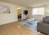Thumbnail 7 of 19 - A living room with a grey couch and a television at Winston Apartments, Baltimore, Maryland