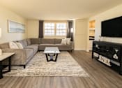 Thumbnail 2 of 26 - A living room with a grey couch and a coffee table.