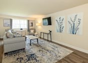 Thumbnail 3 of 27 - A living room with a couch, chair, and a rug.at Deer Park Apartments, Randallstown, MD