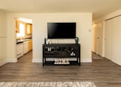 Thumbnail 4 of 26 - A black TV stand with the word HOME on it sits in a living room.