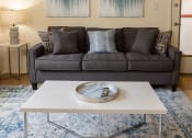 Thumbnail 4 of 19 - A grey couch with a white coffee table at Winston Apartments, Baltimore, Maryland