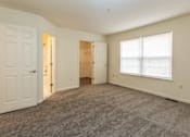 Thumbnail 7 of 22 - Empty bedroom with a closet and a window at Carlson Woods Townhomes, Baltimore