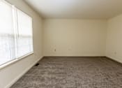 Thumbnail 17 of 22 - an empty room with carpet and window at Carlson Woods Townhomes, Baltimore, MD, 21244