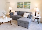 Thumbnail 20 of 21 - A grey couch with a white pillow on it sits in a living room.