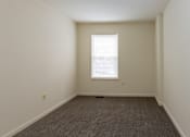 Thumbnail 11 of 22 - a small empty room with a window and carpet at Carlson Woods Townhomes, Baltimore, MD, 21244