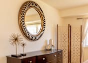 Thumbnail 21 of 21 - A bedroom with a large mirror and a dark brown dresser.