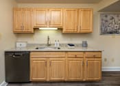 Thumbnail 8 of 25 - A kitchen with wooden cabinets and a granite countertop  at Ivy Hall Apartments*, Maryland, 21204
