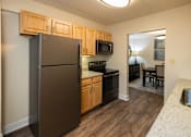 Thumbnail 7 of 25 - A kitchen with wooden cabinets and a granite countertop  at Ivy Hall Apartments*, Maryland, 21204