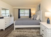 Thumbnail 15 of 25 - Primary bedroom with queen bed, nightstand, and window at Village of Pine Run Apartments & Townhomes*, Maryland, 21244