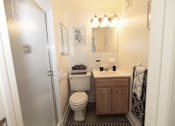 Thumbnail 18 of 25 - A bathroom with a toilet, sink, and mirror.
