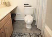 Thumbnail 7 of 25 - A bathroom with a toilet, sink, and shower.