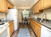 Thumbnail 6 of 25 - A kitchen with wooden cabinets and a white refrigerator.