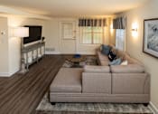 Thumbnail 4 of 32 - A living room with a couch, a coffee table, and a television at Spring Hill Apartments & Townhomes, Baltimore, MD 21234. .