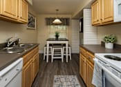 Thumbnail 10 of 32 - Eat-in kitchen with wooden cabinets and a dishwasher at Spring Hill Apartments & Townhomes, Baltimore, MD 21234.