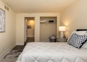 Thumbnail 19 of 32 - A bedroom with a large bed and a painting on the wall. Spring Hill Apartments & Townhomes, Baltimore, MD 21234
