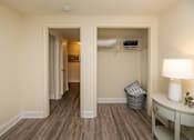 Thumbnail 21 of 32 - A room with a desk and a closet. Spring Hill Apartments & Townhomes, Baltimore, MD 21234