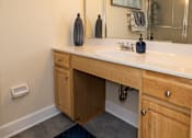 Thumbnail 22 of 32 - A bathroom with a vanity and a mirror. Spring Hill Apartments & Townhomes, Baltimore, MD 21234