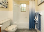 Thumbnail 16 of 22 - A white toilet sits next to a bathtub in a bathroom.