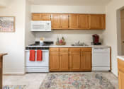 Thumbnail 2 of 15 - a kitchen with white appliances and wooden cabinets at Lawyers Hill Apartments, Elkridge, 21075