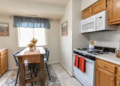 Thumbnail 3 of 15 - a kitchen with a table and chairs in front of a window at Lawyers Hill Apartments, Elkridge, 21075