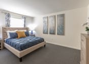 Thumbnail 6 of 15 - a bedroom with a bed and three paintings on the wall at Lawyers Hill Apartments, Elkridge, MD, 21075