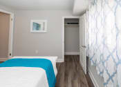 Thumbnail 14 of 24 - a bedroom with gray walls and a white and blue bedspread at Fairbrook Park, Baltimore, MD