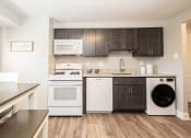 Thumbnail 7 of 24 - A kitchen with dark wood cabinets and white appliances at Fairbrook Park, Baltimore, 21244
