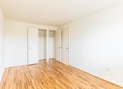 Thumbnail 16 of 22 - Empty bedroom with white walls and wooden floors at Foxridge Townhomes, Baltimore, 21221
