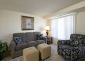 Thumbnail 7 of 9 - Living room with a couch and two chairs at Yorktowne Townhomes Apartments, Pennsylvania, 17331