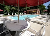 Thumbnail 23 of 25 - a swimming pool with a table and chairs