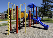 Thumbnail 8 of 10 - A playground with a blue slide and yellow and red play structures at Colony Hill Apartments & Townhomes, Baltimore, MD