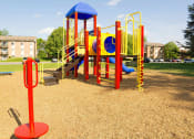 Thumbnail 24 of 24 - Colorful playground in a park with apartment buildings in the background at Fairbrook Park, Baltimore, 21244