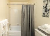 Thumbnail 16 of 29 - Primary bathroom with tub shower at Woodridge Apartments in Randallstown, MD 21133.