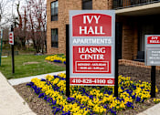 Thumbnail 26 of 28 - A sign for Ivy Hall Apartments leasing center is displayed in front of a building.
