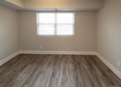 Thumbnail 10 of 25 - Empty room with hardwood floors and a window at McDonogh Village Apartments & Townhomes, Randallstown, Maryland