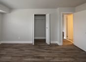 Thumbnail 13 of 25 - Bedroom with grey walls and wood floor at McDonogh Village Apartments & Townhomes, Randallstown