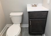 Thumbnail 19 of 25 - Small bathroom with a toilet sink and mirror at McDonogh Village Apartments & Townhomes, Randallstown, MD