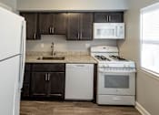Thumbnail 3 of 25 - Kitchen with white refrigerator at McDonogh Village Apartments & Townhomes, Randallstown, Maryland