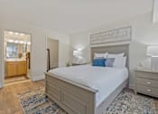Thumbnail 9 of 19 - A bedroom with a large bed, a dresser, and a mirror at Woodsdale Apartments in Abingdon, MD