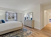 Thumbnail 8 of 19 - A bedroom with a large bed, a dresser, and a mirror at Woodsdale Apartments in Abingdon, MD