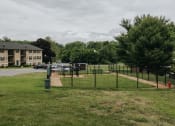 Thumbnail 28 of 29 - Fenced in Dog Park with benches at Woodridge Apartments in Randallstown, MD 21133.