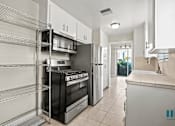 Thumbnail 42 of 62 - Kitchen with a Stainless-Steel Stove, Refrigerator, Microwave Oven, and Shelving