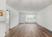 Thumbnail 7 of 23 - A room with wooden floors and white walls.